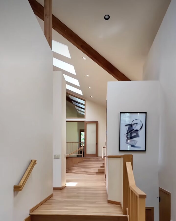 The stair hall of the Westdale house, skylights cut into a cedar ceiling.